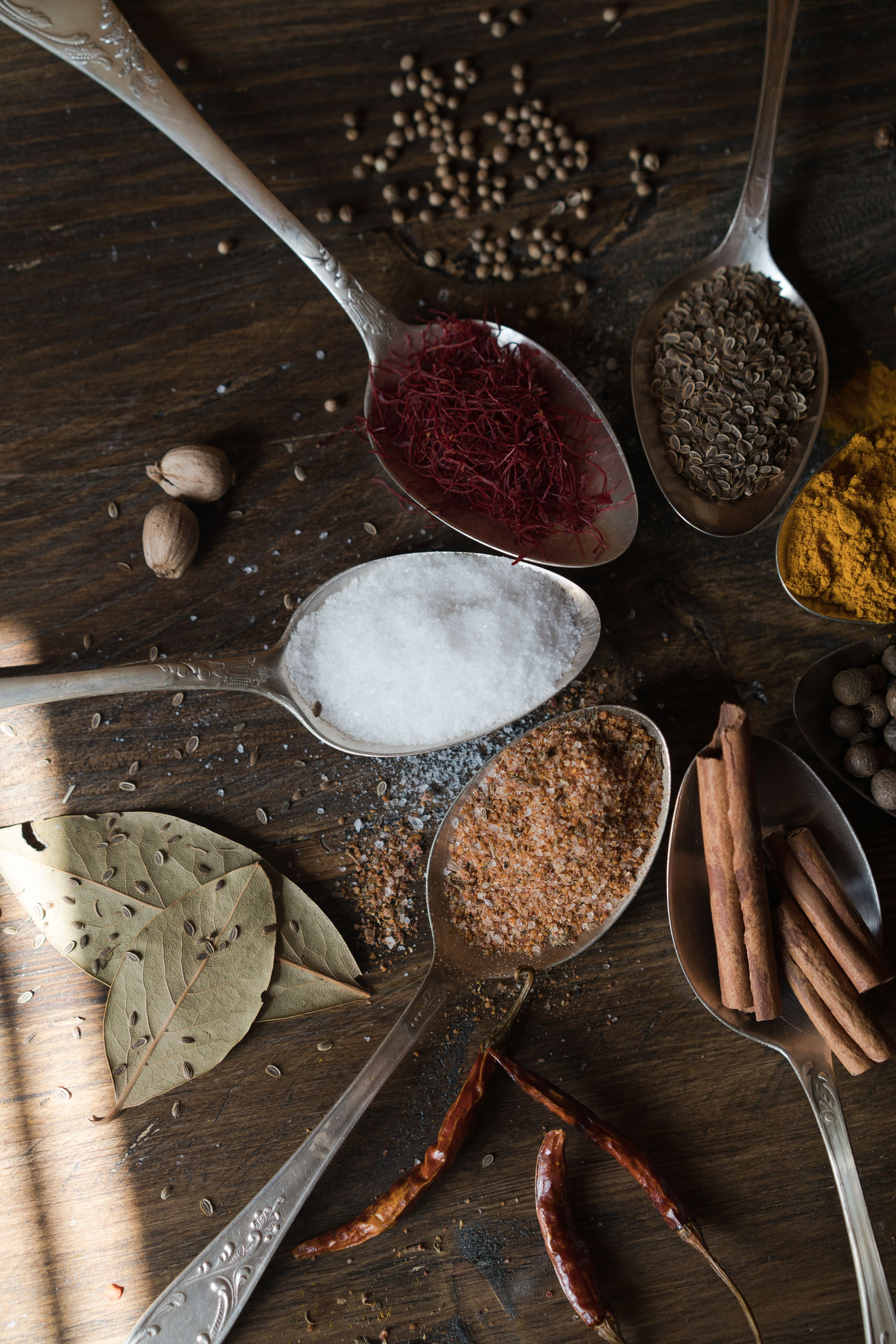 Whole spices with cinnamon, pepper, and bay leaf arranged on wood